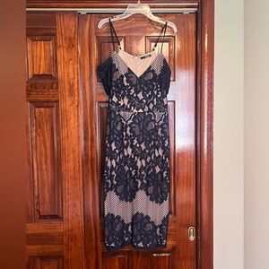 Navy lace overlay dress with off the shoulder lace sleeve.